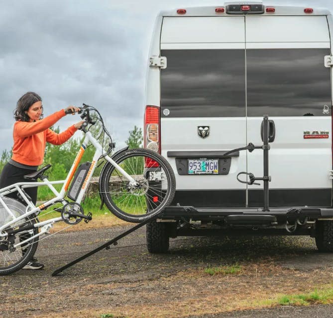 Yakima OnRamp LX installed on back of RV with ramp out and bike being wheeled up on it. 